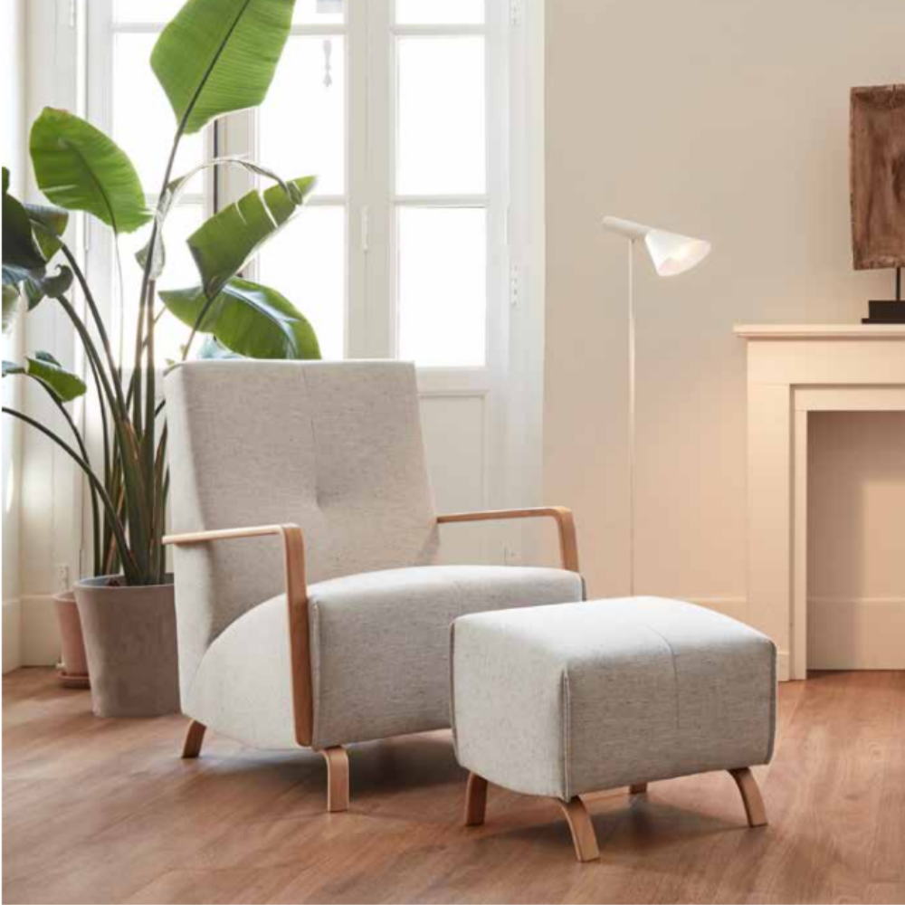 Butaca con pouf de diseño nórdico modelo KOYO en un ambiente de saon minimalista con chimenea