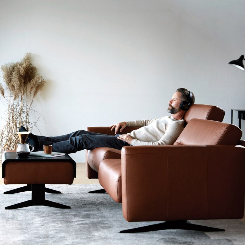 Hombre relajandose en un sofá de Stressless Disponible en nuestras tiendas de diseño Sidivani en Madrid y en nuestra web